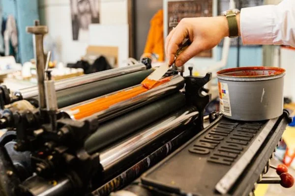 someone putting ink on a printing roll